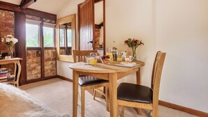 A dining area with a wooden table, chairs, and breakfast items.