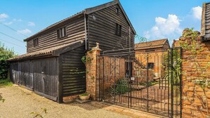 A rustic wooden building with a metal gate and brick walls.