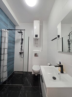 Ein modernes Badezimmer mit Dusche, Toilette und Waschbecken.