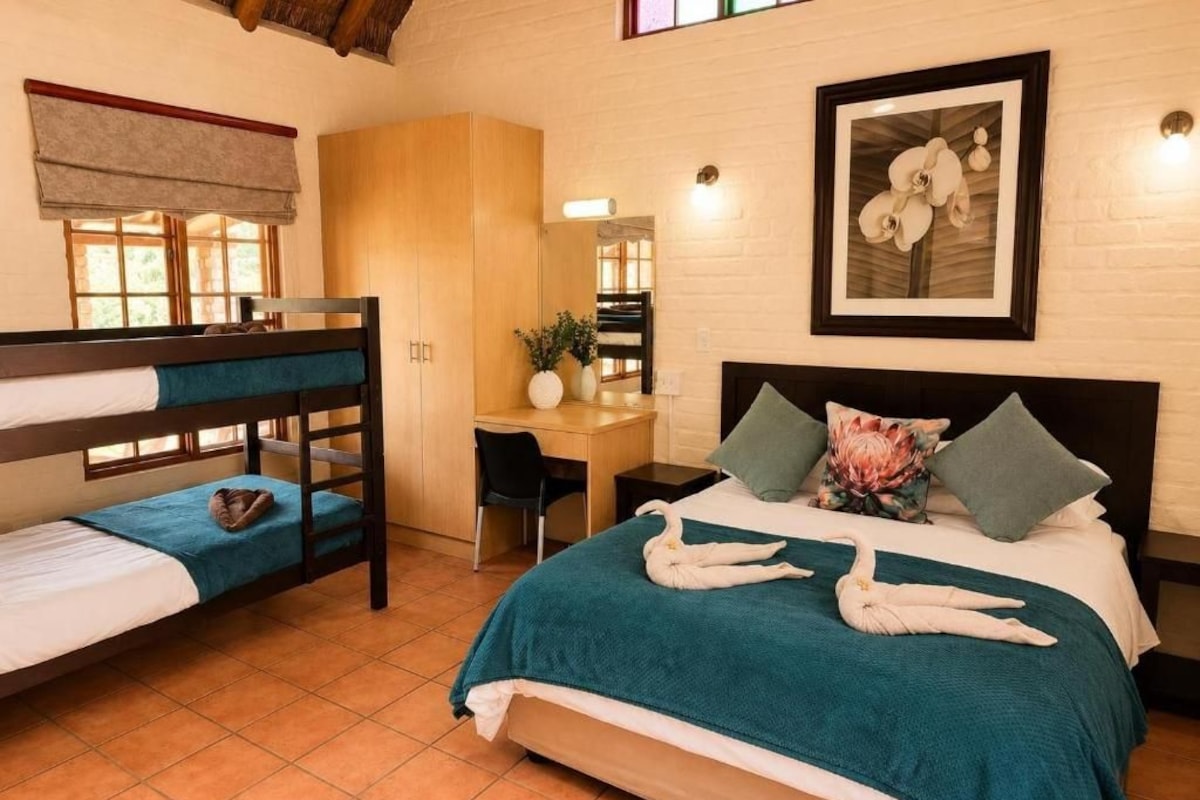 Ein Schlafzimmer mit Etagenbetten, einem Schreibtisch und einem Bett mit dekorativen Schwanen.