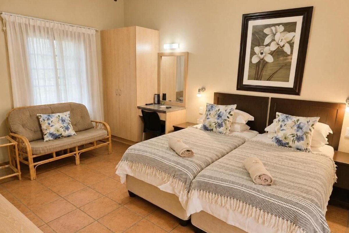 Ein Hotelzimmer mit einem Bett, einer Couch, einem Schreibtisch und einem Kleiderschrank.