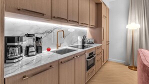 Cuina moderna amb encimera de marbre, electrodomèstics d'acer inoxidable i armaris de fusta.