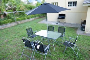A patio with a table and chairs, an umbrella, and a grill in the background. - Pierocks Highgate with  Free Parking , WI-FI (Arnos Vale)