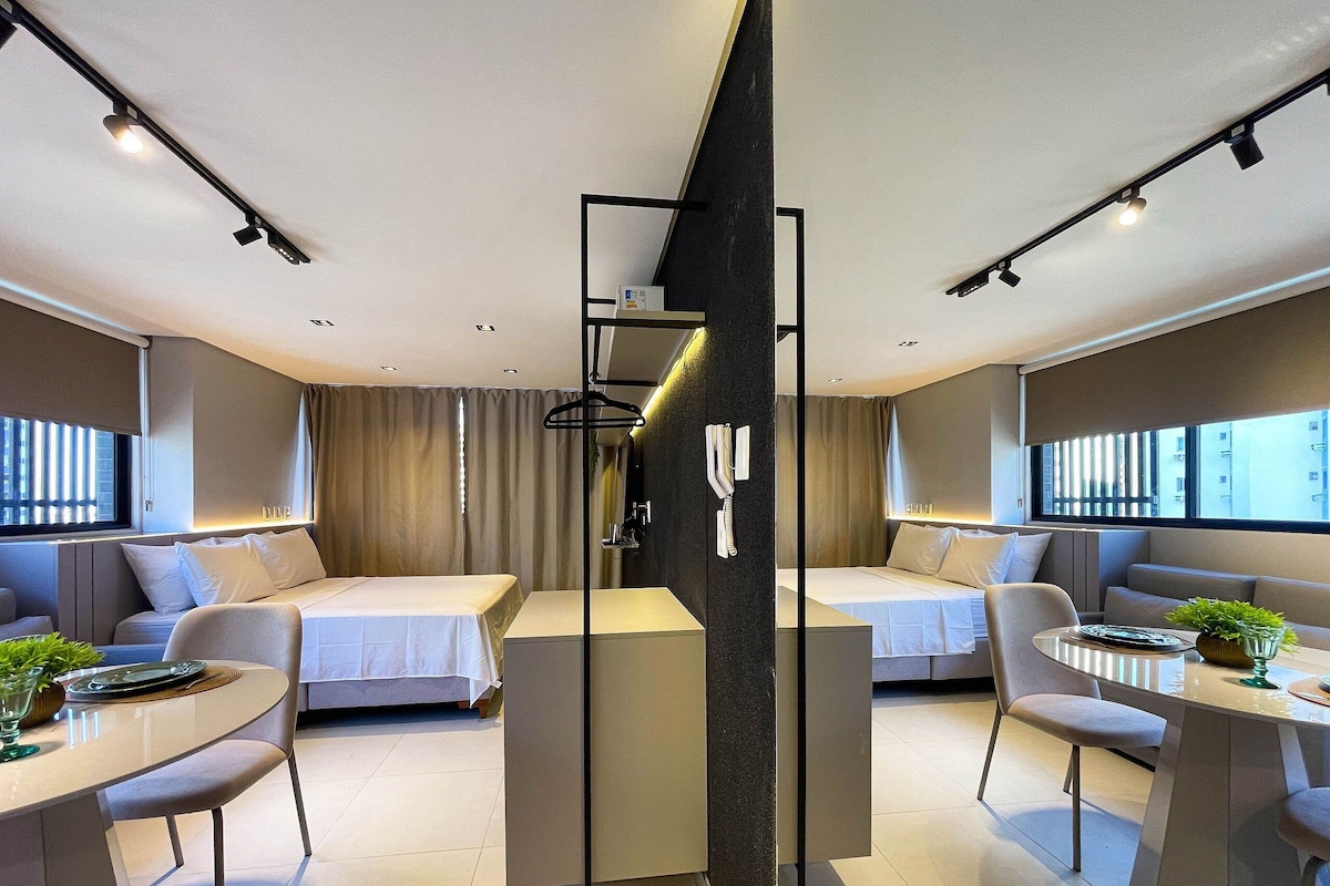 Ein modernes Hotelzimmer mit zwei Betten, einer Essecke und einem großen Fenster.