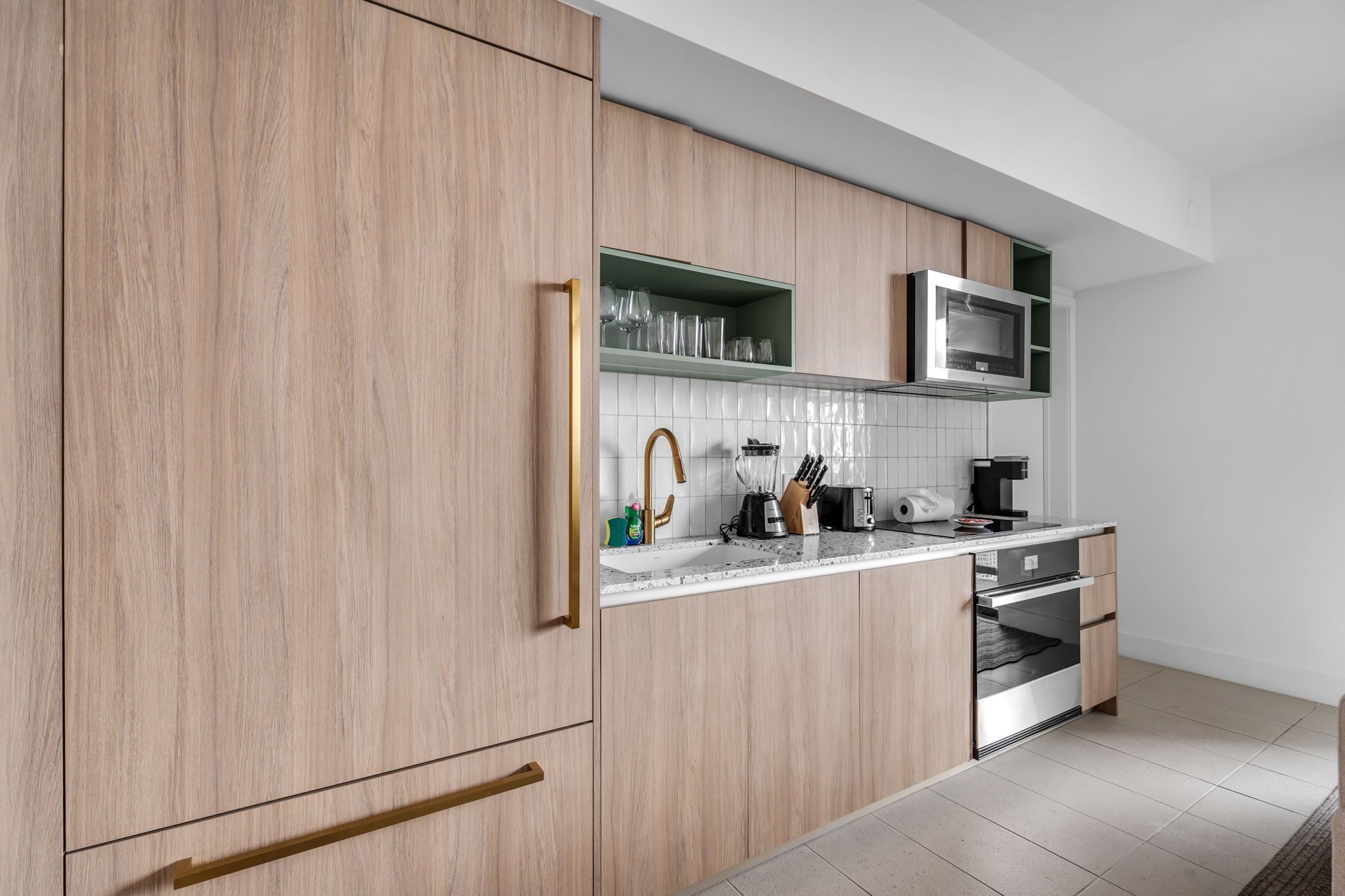 A modern kitchen with wooden cabinets, a microwave, a sink, and a dishwasher.