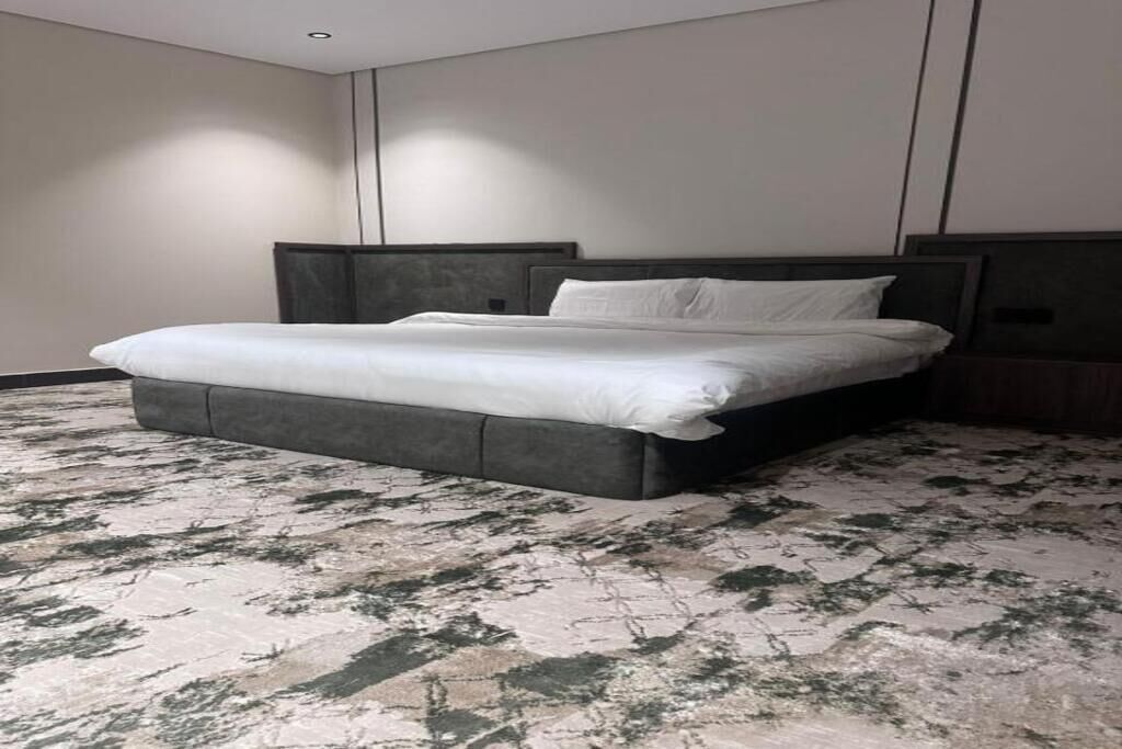 Una camera da letto moderna con un letto grande, una testiera e un tappeto a motivi.