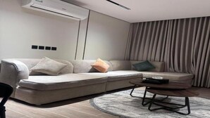 Una sala de estar moderna con un sofá modular, una mesa de centro y un tapete estampado.