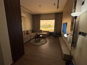 Una sala de estar moderna con un sofá, una mesa de centro y un televisor.