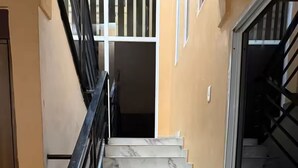 Eine Treppe mit Marmorstufen und schwarzen Geländern, die zu einer Zwischenebene führt.
