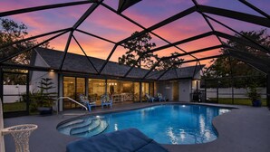 A swimming pool with lounge chairs, a basketball hoop, and a covered patio area. - Footprints In The Sand | 3BR Private Pool Home | Near Palm Coast and Flagler Beaches (Palm Coast)