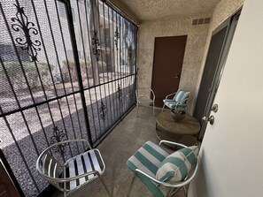 A small balcony with metal railings, a chair, a cushioned bench, and a door. - Jamming Jericho 2 bedrooms (Las Vegas)