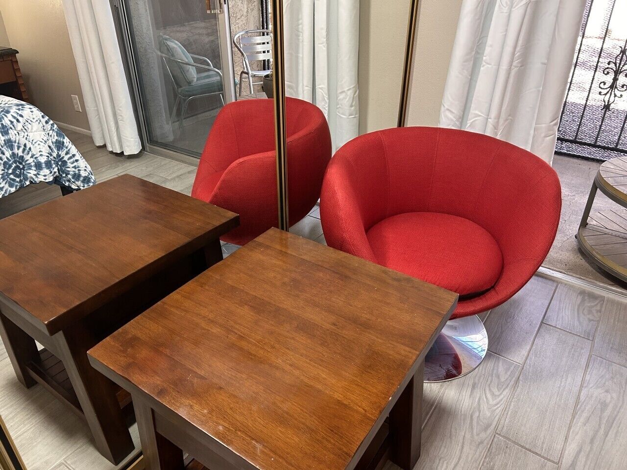 Una habitación con una mesa de madera, dos sillas rojas, un ventanal corredero y vistas al exterior.