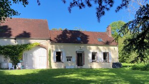 A two-story house with a garage, a covered porch, and a well-maintained lawn.