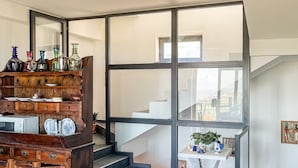 Een modern interieur met een trap, een eethoek en uitzicht op het exterieur.
