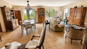 A spacious kitchen with a dining area, a large wooden cabinet, and a chandelier. - La Musardière - Air Conditioning, Pool with a View - Sleeps 8 (Villeneuve-lès-Avignon)