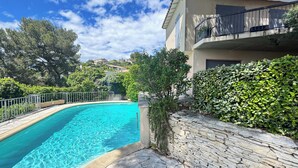 A swimming pool with stone tiles, a stone wall, and a balcony with a railing. - La Musardière - Air Conditioning, Pool with a View - Sleeps 8 (Villeneuve-lès-Avignon)