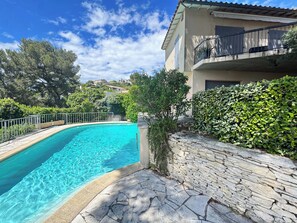A swimming pool with stone tiles, a stone wall, and a balcony with a railing. - La Musardière - Air Conditioning, Pool with a View - Sleeps 8 (Villeneuve-lès-Avignon)