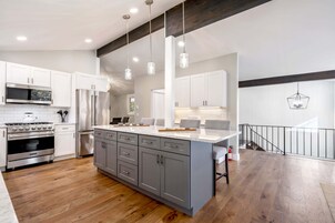 Una cocina moderna con armarios blancos, electrodomésticos de acero inoxidable y una isla grande.