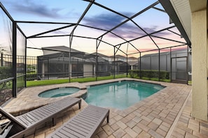 Piscina ao ar livre coberta com espreguiçadeiras e vista para edifícios residenciais.