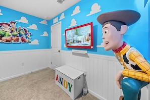 A room with a blue wall, a white door, a television mounted on the wall, and a white dresser with the name 'ANDY' on it. - 6BR house with pool near Disney area (Kissimmee)