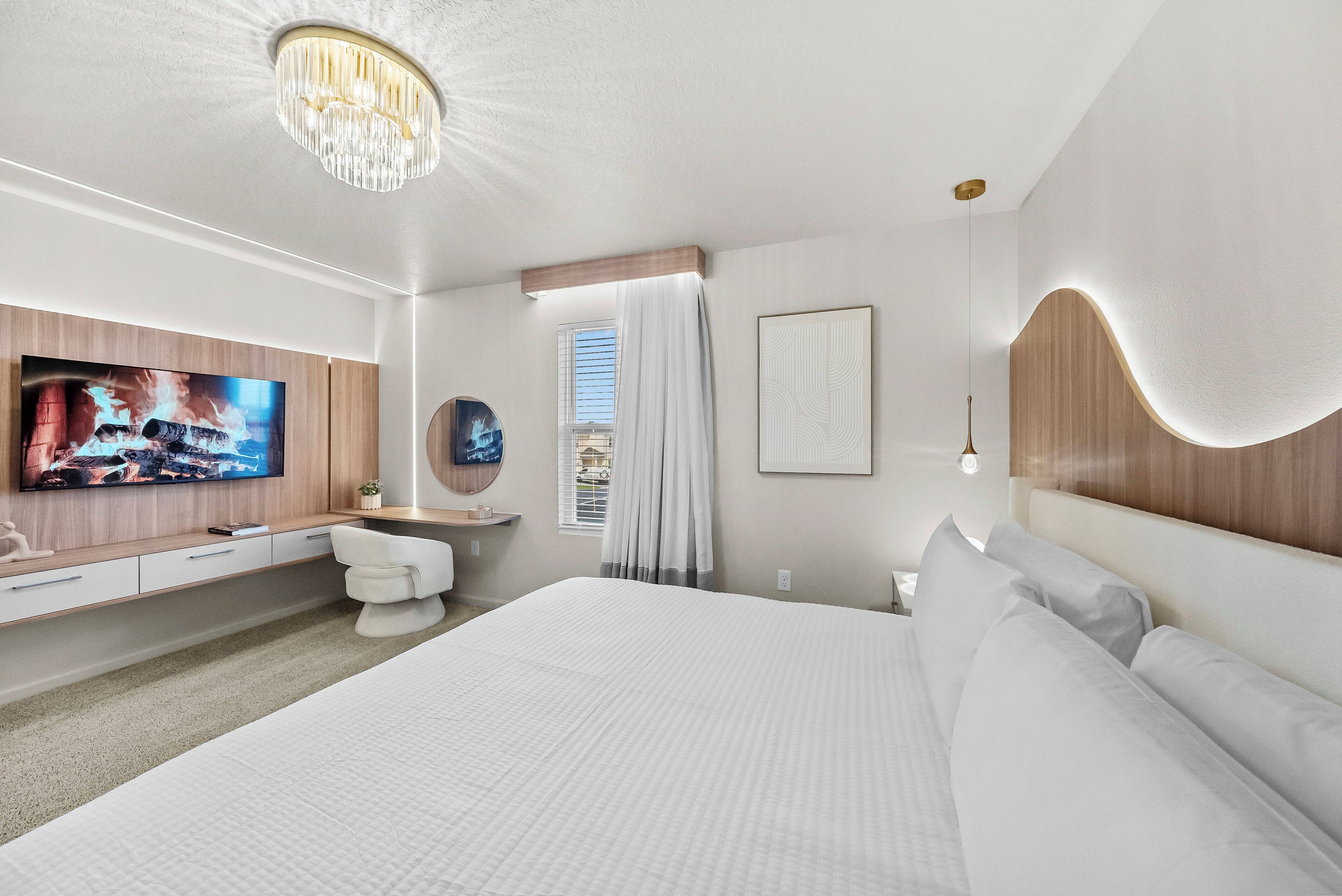 Een moderne hotelkamer met een groot bed, een bureau, een televisietoestel en een badkamer.