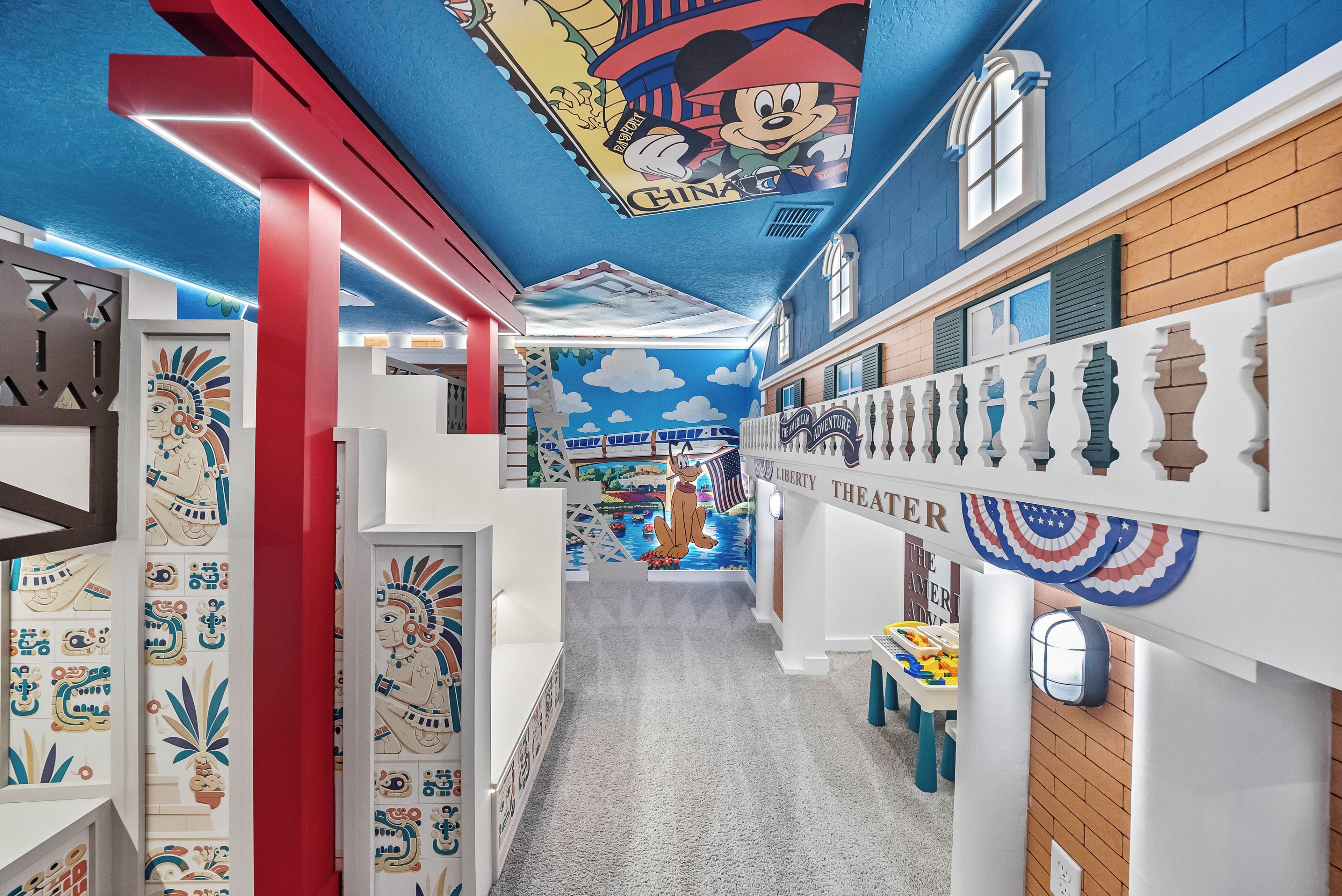 A children's play area with colorful murals, a slide, and a playhouse.