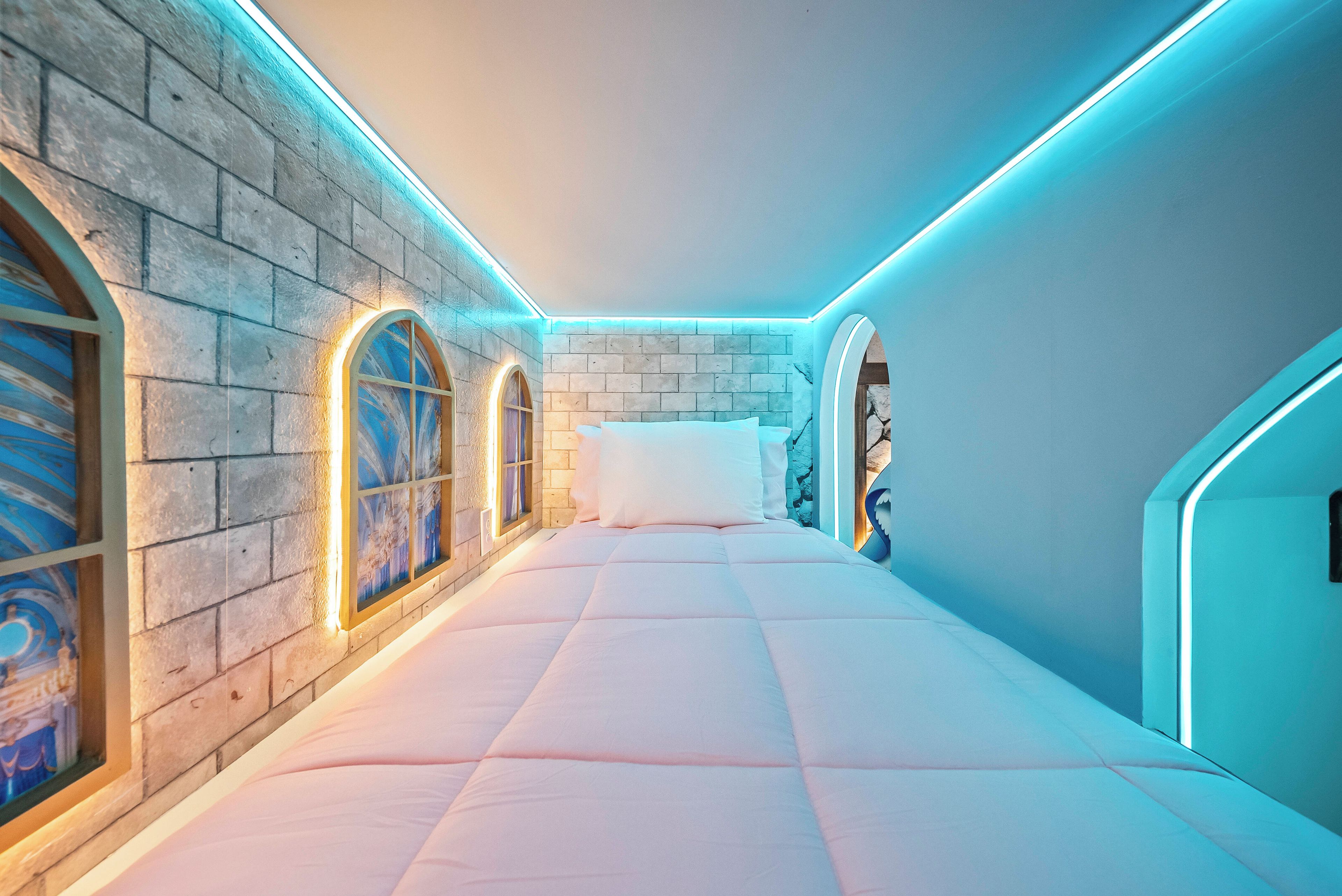 Un dormitorio moderno con cama, paredes de piedra y ventanas de arco.