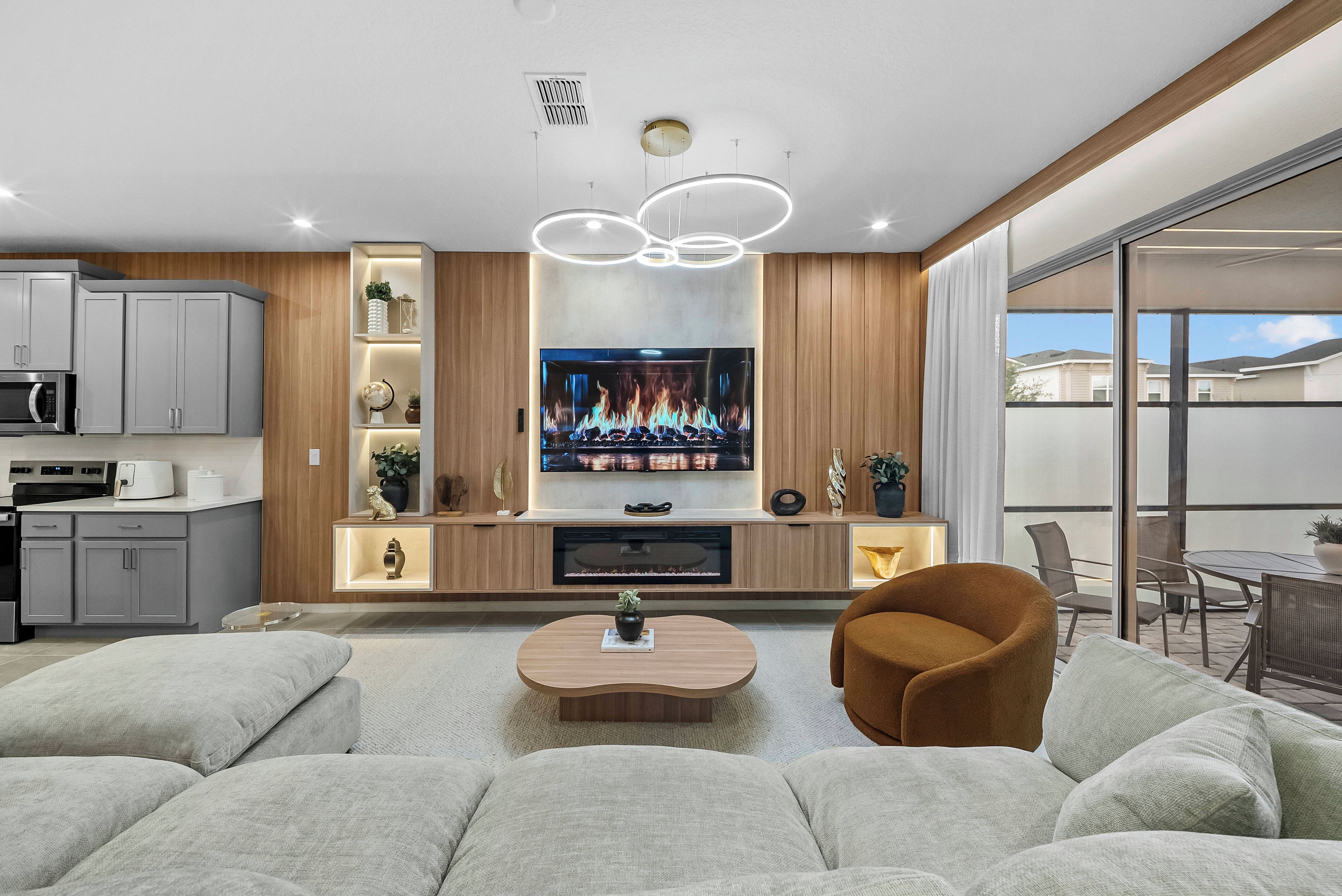 A modern living room with a flat-screen TV, a coffee table, and comfortable seating.