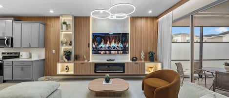 Una sala de estar moderna con un televisor de pantalla plana, una mesa de centro y asientos cómodos.
