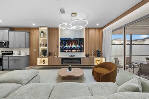 Un salon moderne doté d’un téléviseur à écran plat, d’une table basse et de sièges confortables.