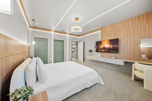 Une chambre à coucher moderne avec un lit, une télévision et un lustre.