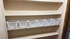 A white shelving unit with multiple white plastic baskets.