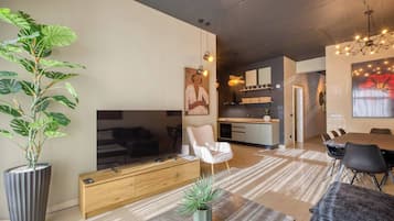 Una sala de estar moderna con un sofá, una mesa de comedor y una cocina al fondo.