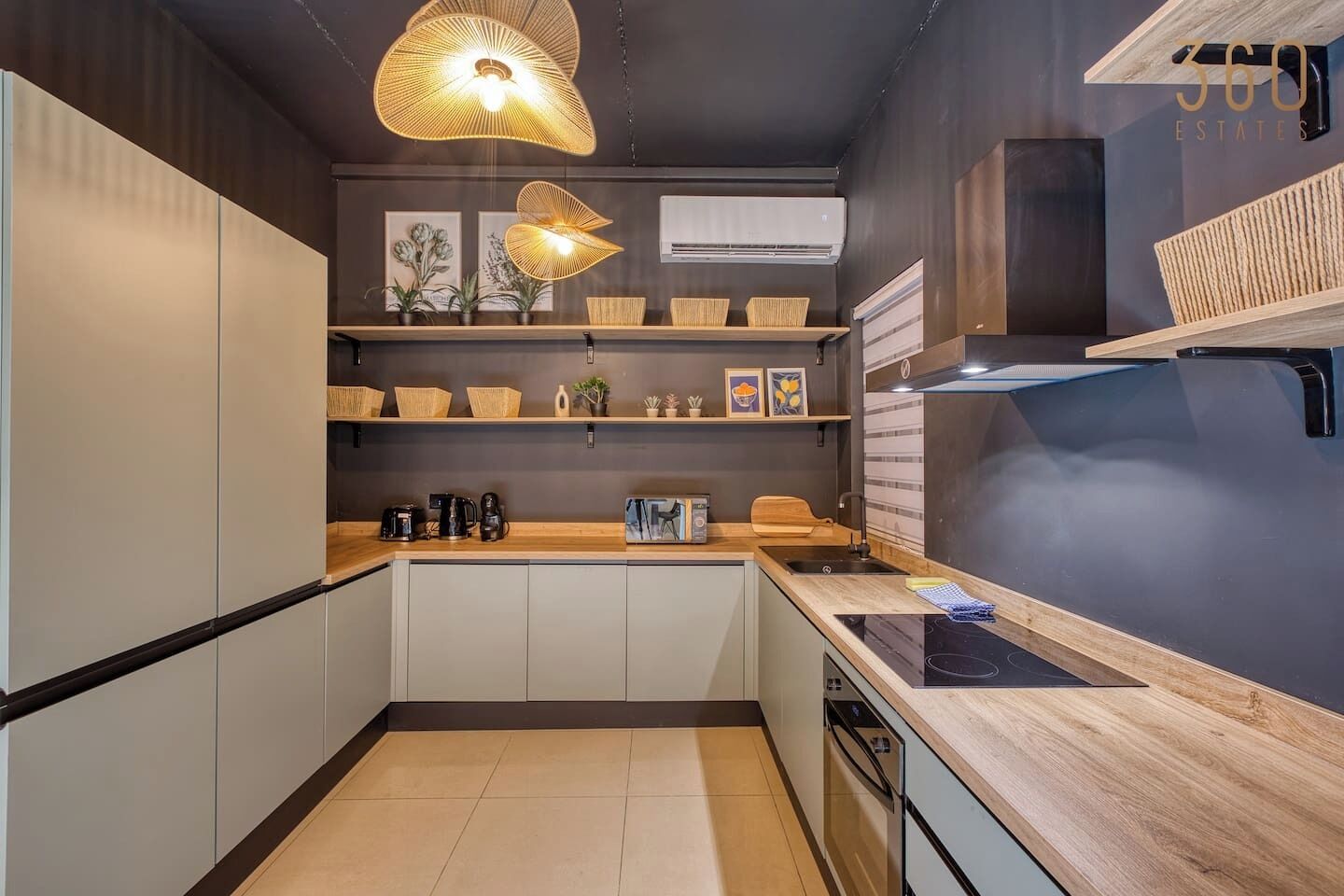 A modern kitchen with a wooden countertop, a built-in oven, and a hanging light fixture.