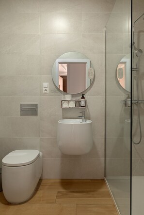 Un baño moderno con inodoro, lavabo y ducha.