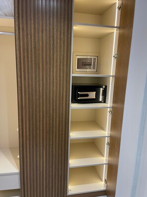 A wooden wardrobe with multiple shelves, a built-in safe, and a black electronic device. -  Hotel Lina Oldcity  (Istanbul)