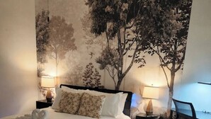 Ein Schlafzimmer mit einem Bett, zwei Nachttischen, einem Schreibtisch und einem Stuhl.