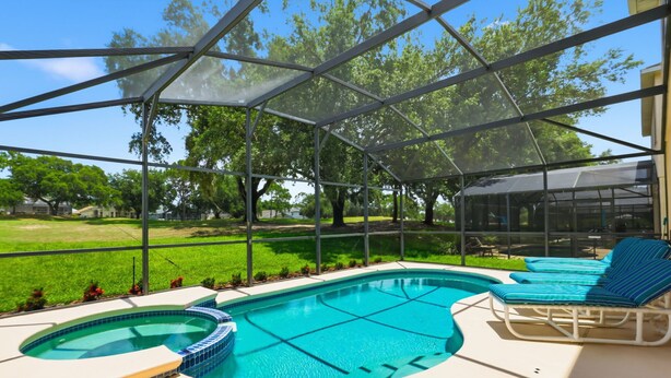 Una piscina con hidromasaje, rodeada por una zona techada con sillones de descanso.