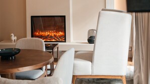 A modern living room with a fireplace, a chandelier, and a comfortable seating area.
