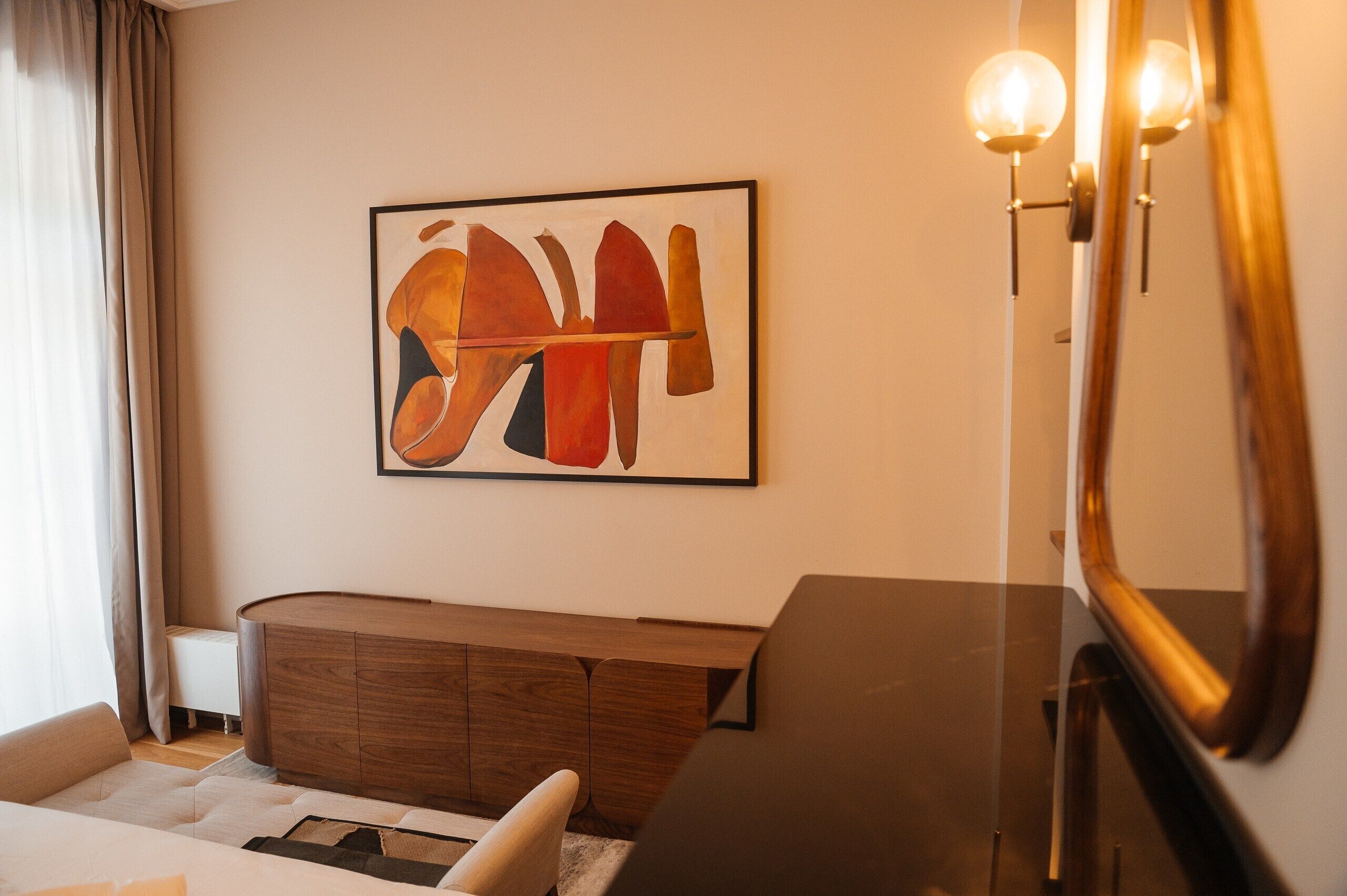 Ein modernes Wohnzimmer mit einem Holzkabinett, einem Sofa, einem Couchtisch und einem Gemälde an der Wand.