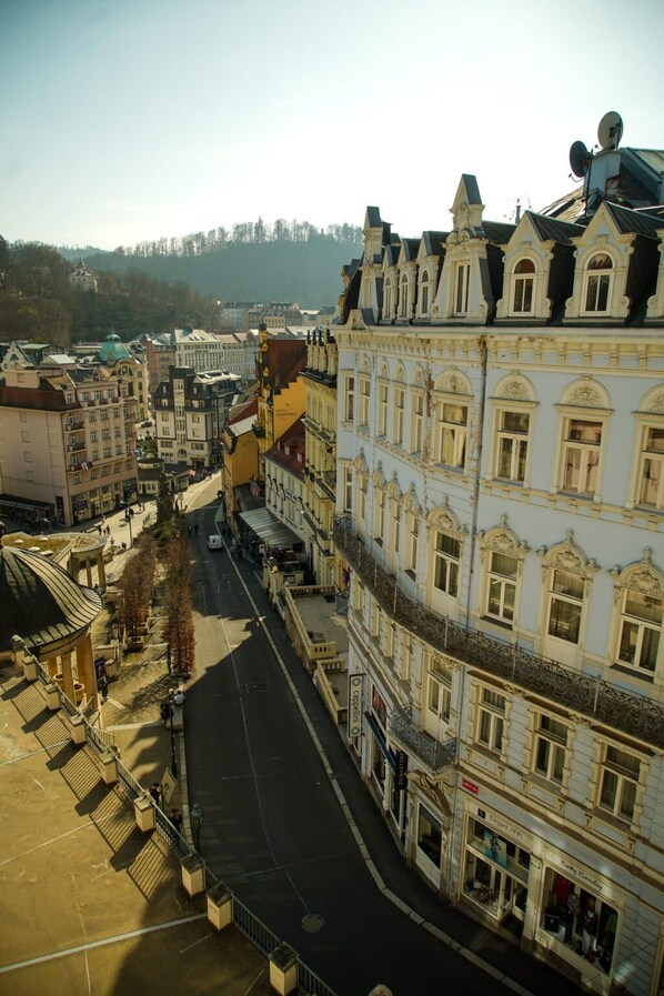 A multi-story building with ornate architectural details, a central courtyard, and a street in front.