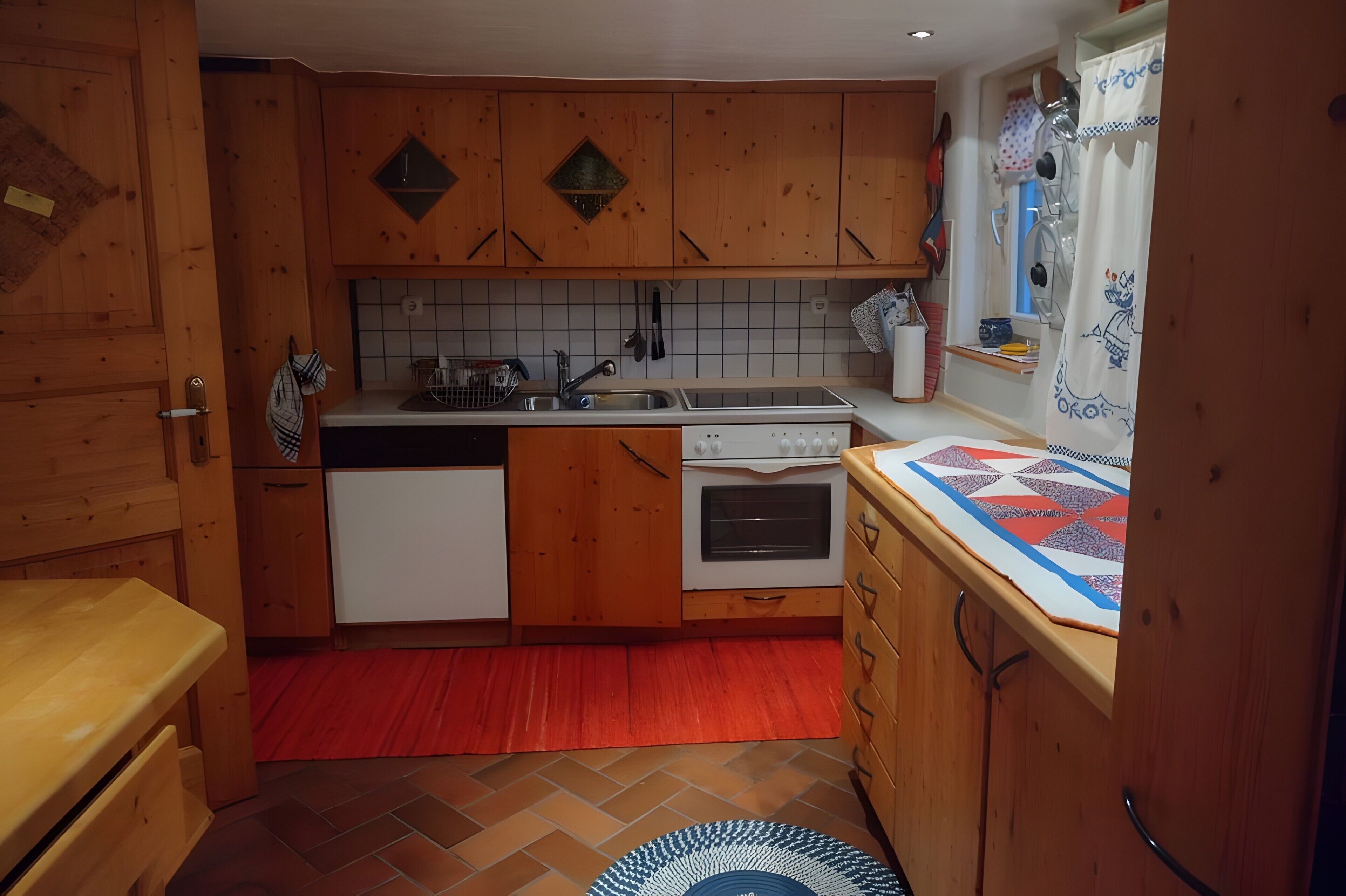 Eine Küche mit Holzausstattung, einem Geschirrspüler, einer Spüle und einem Fenster mit Vorhängen.