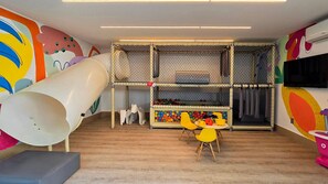 Uma área de recreação com escorrega, piscina de bolinhas e casinha.