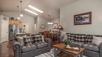 Een woonkamer met twee banken, een salontafel, en een eethoek met stoelen en een tafel.