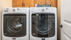 Two Maytag front-loading washing machines in a laundry room with wooden cabinets above. - Golf Course Townhome 3 bed/3 bath, Private Hot Tub (Columbia Falls)