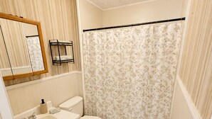 A bathroom with a sink, toilet, and shower curtain.