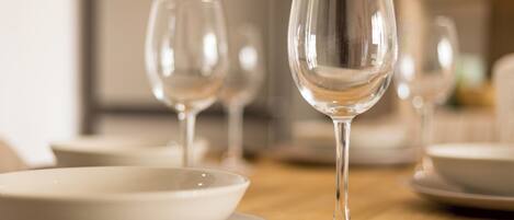 A dining table with clear glassware and white dinnerware.