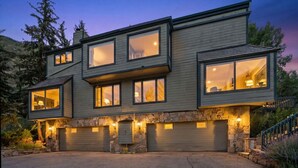 A modern two-story house with large windows, a stone facade, and a garage. - Gore Range Retreat I Mountain Views & Adventure (Vail)