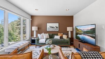 A living room with a sofa, two side tables, a coffee table, and a TV.