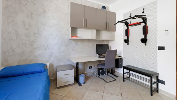 A bedroom with a bed, desk, chair, and a pegboard wall with hooks. - 'Dimora Del Principe' with Sea View, Wi-Fi and Air Conditioning (Principe)
